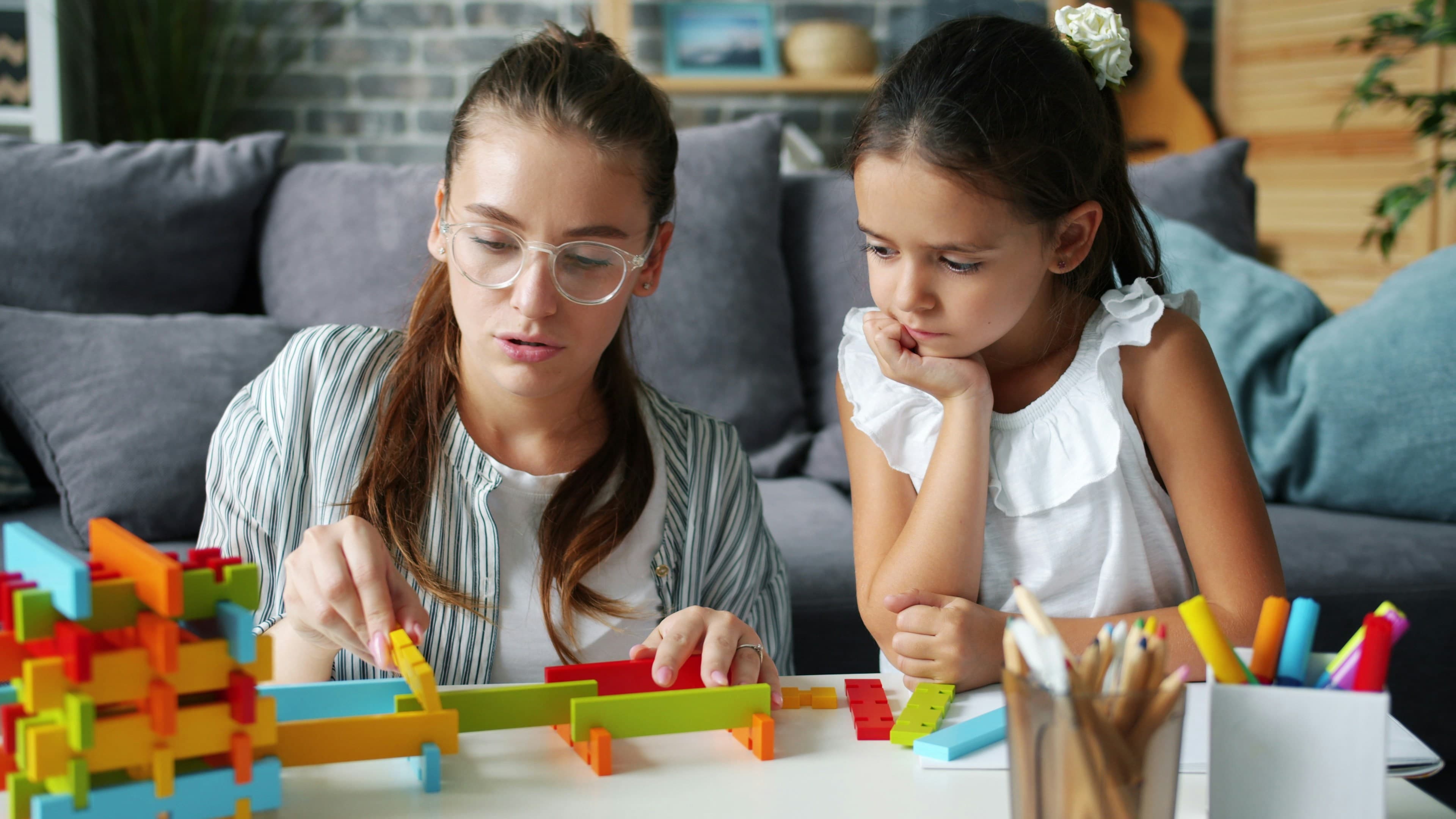 Une femme et une fille construisent avec des blocs colorés.